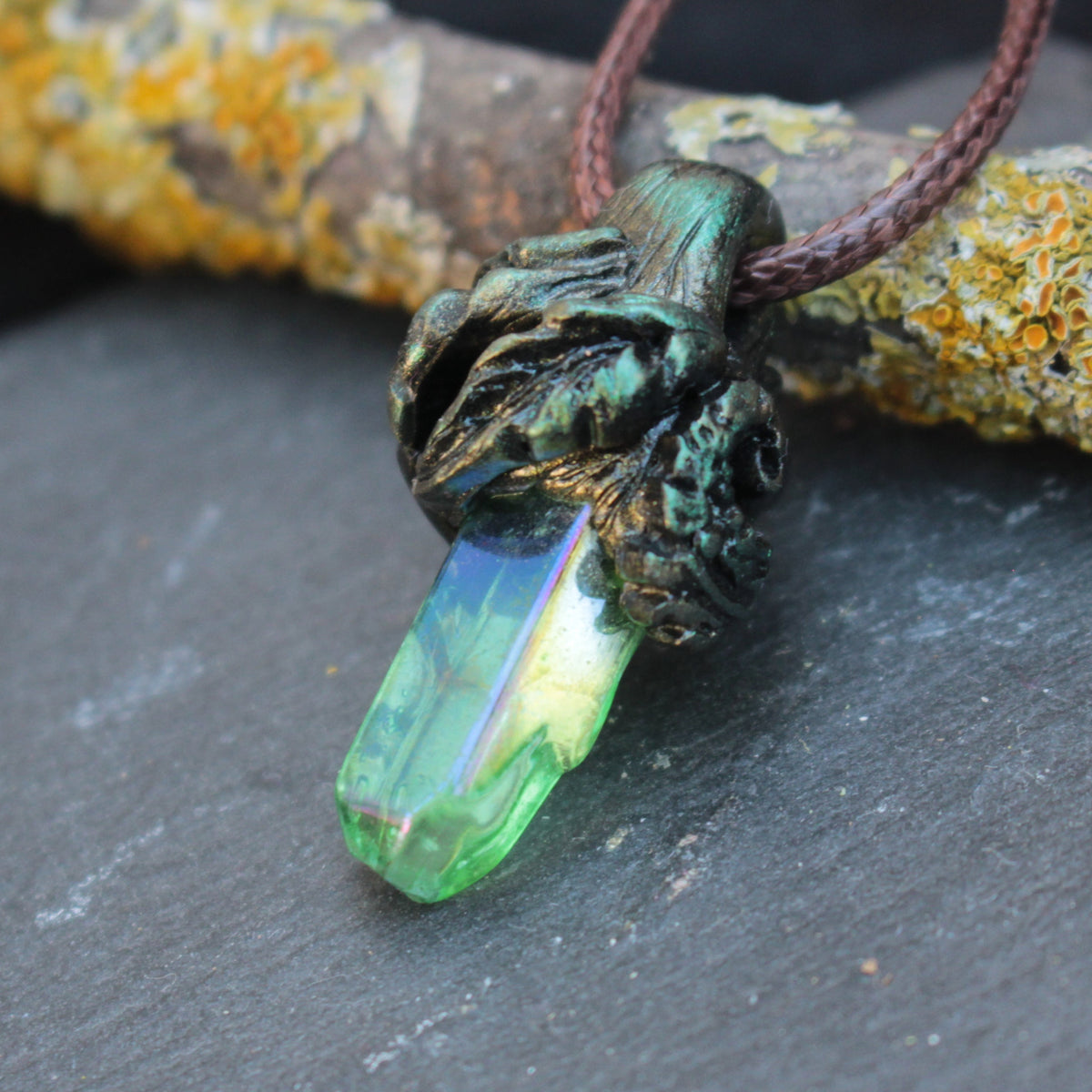 The Elarwyn Crystal pendant necklace with a glowing green and blue crystal and forest-inspired bronze setting
