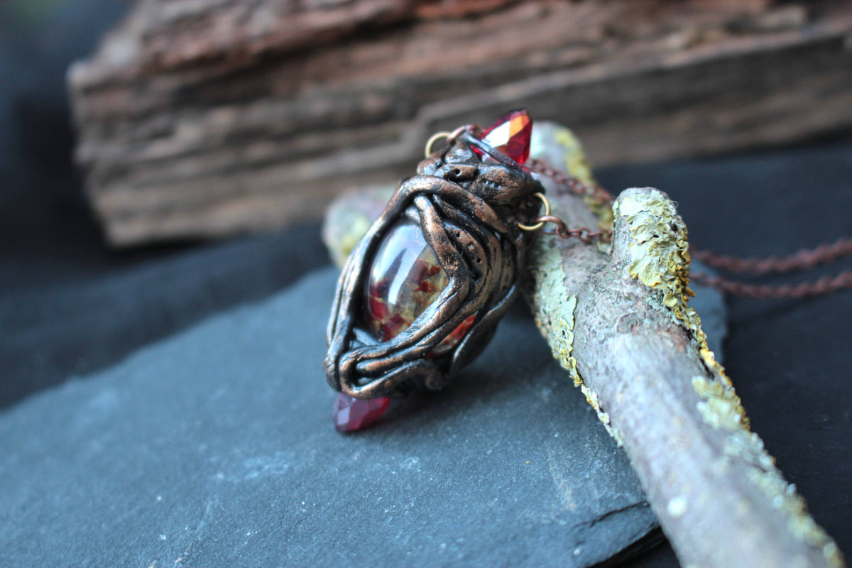 Fantasy amulet with three red crystals symbolizing strength, loyalty and togetherness