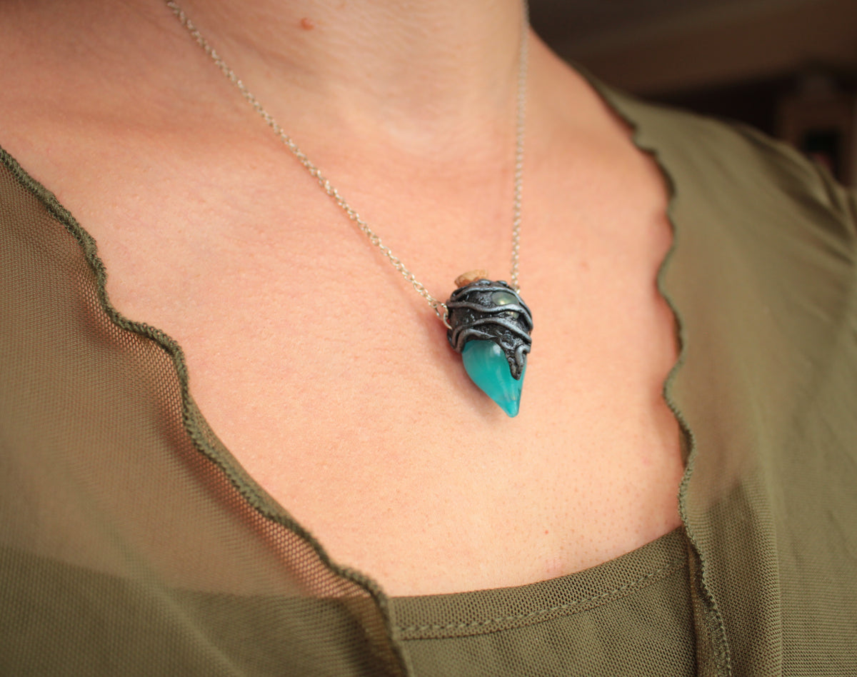 Fantasy jewelry necklace featuring a turquoise potion bottle that glows green in darkness