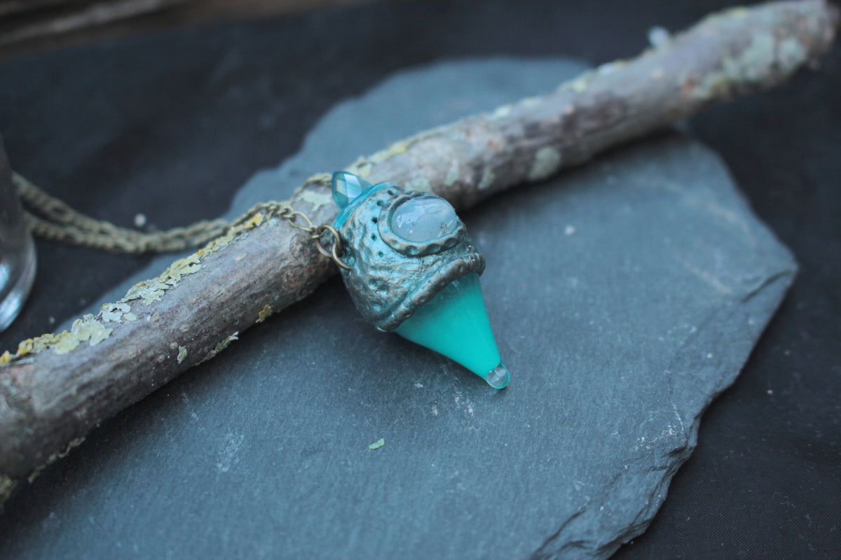Turquoise potion necklace glowing in the dark with an enchanted fantasy look