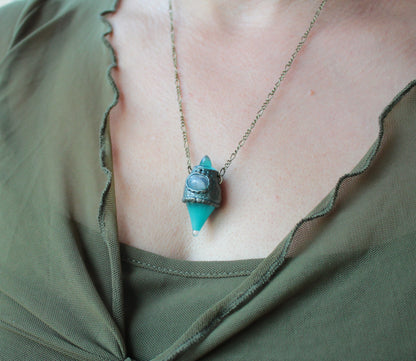 Turquoise potion jewelry with a glowing miniature bottle and fantasy-inspired design