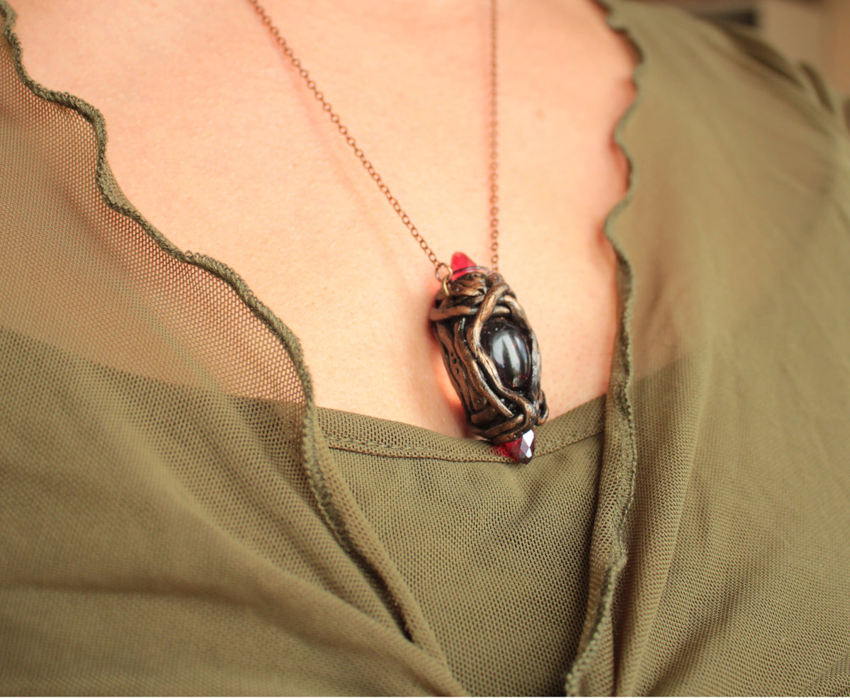 One-of-a-kind fantasy necklace featuring red crystals and an enchanted antique-style finish