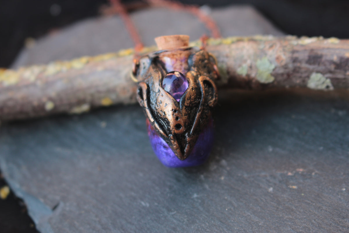 Close-up of a purple potion pendant in an ornate bronze setting