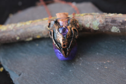 Close-up of a purple potion pendant in an ornate bronze setting