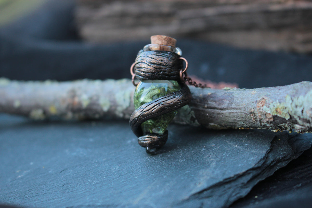 Handmade fantasy necklace featuring a green vial filled with woodland-inspired details