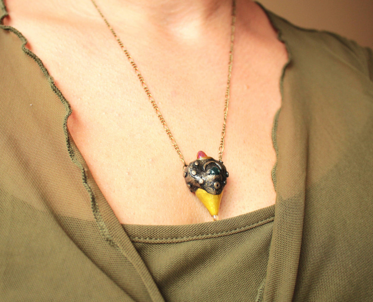 Handmade forest inspired pendant with a green gemstone and bronze finish