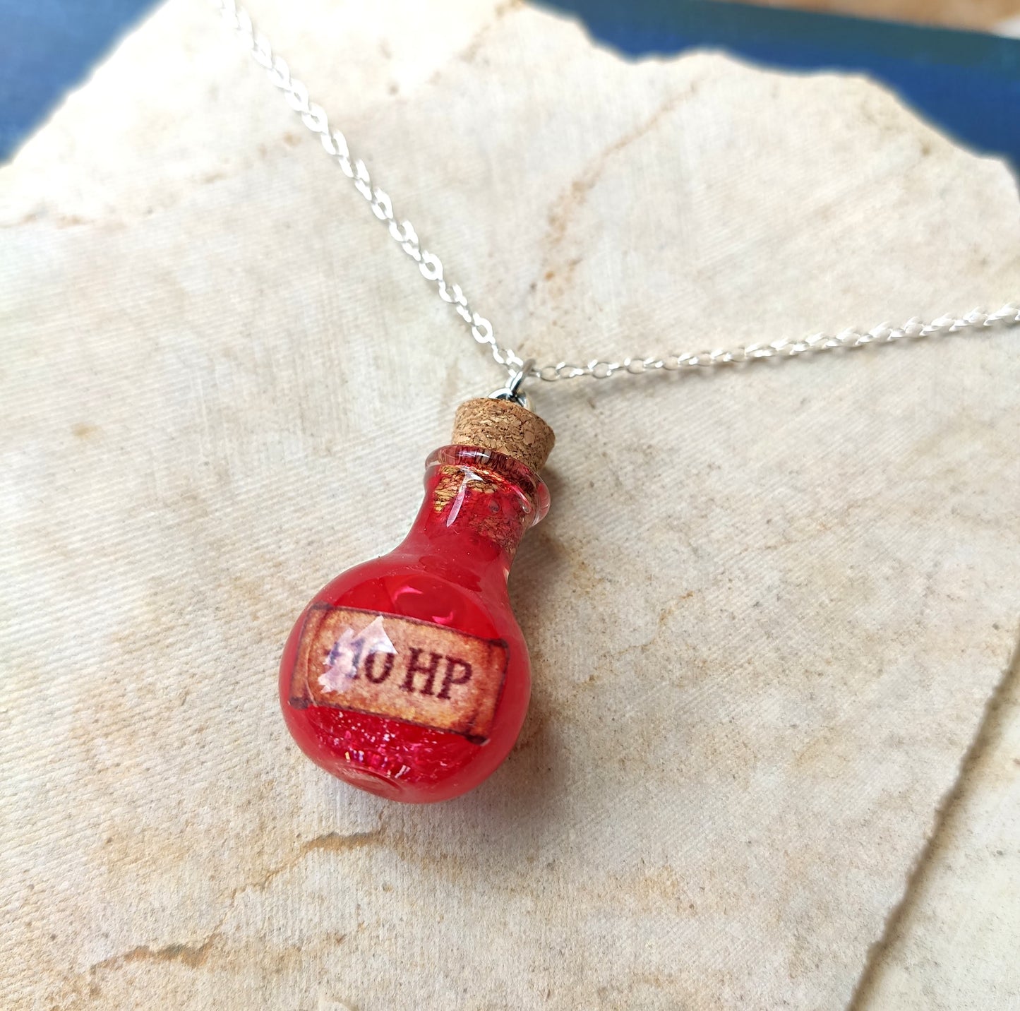 close up of healing potion glass vial pendant handmade fantasy jewelry